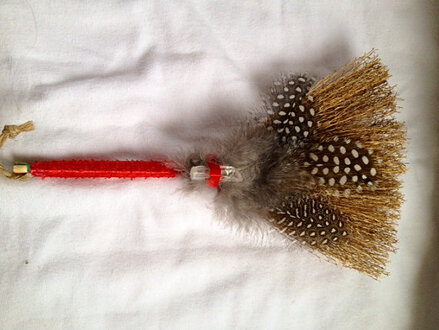 Customer appreciation photo of a broom with guinea feathers from Running Bug Farm.