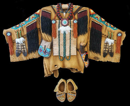 Picture of a Native American ceremonial wood carved shirt with real feathers from Running Bug Farm.