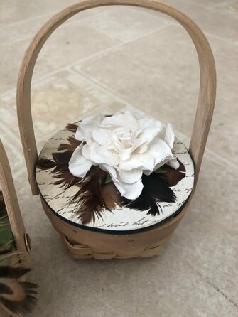 Picture of a basket with a handmade flower using real feathers as leaves. Running Bug Farm.