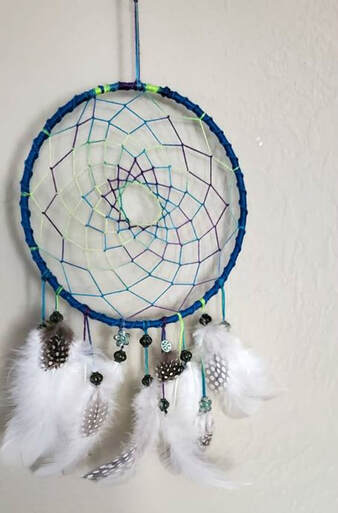 Customer picture featuring cruelty free white feathers and guinea feathers with polka dots from Running Bug Farm used in a handmade dream catcher.