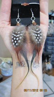 Customer appreciation photo of long dangle feather earrings made using humane feathers sold by Running Bug Farm.